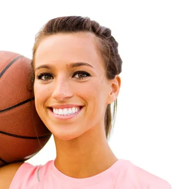 A lady smiling with a basketball
